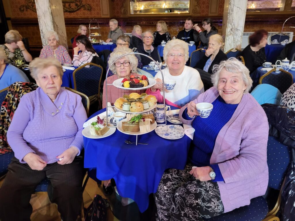 4 visually impaired ladies sitting at a table, enjoying afternoon tea at Blackpool Tower Ballroom