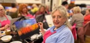 Image of Fiona, Warrington VIP CEO, painting during a fundraiser.